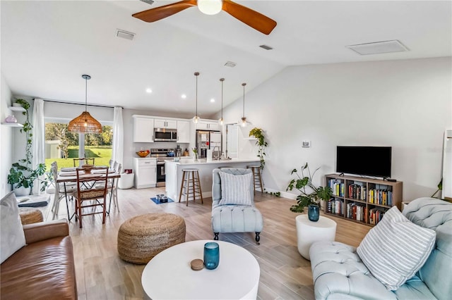 living room with vaulted ceiling, light hardwood / wood-style flooring, and ceiling fan