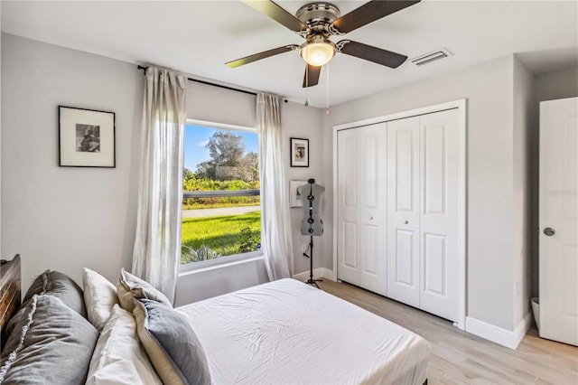 bedroom with a closet, light wood-type flooring, and ceiling fan