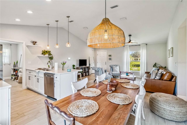 dining space featuring light hardwood / wood-style flooring, lofted ceiling, sink, and ceiling fan