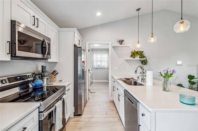 kitchen featuring sink, white cabinetry, stainless steel appliances, lofted ceiling, and decorative light fixtures