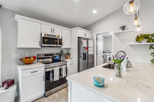 kitchen featuring lofted ceiling, washer and clothes dryer, stainless steel appliances, and white cabinets