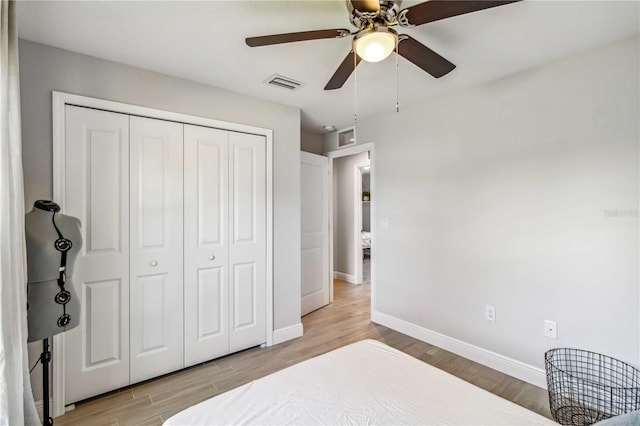 bedroom with light hardwood / wood-style flooring, a closet, and ceiling fan