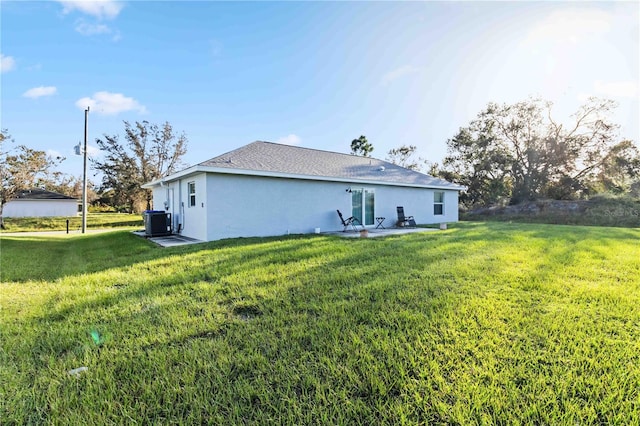 rear view of property with a yard and central AC unit