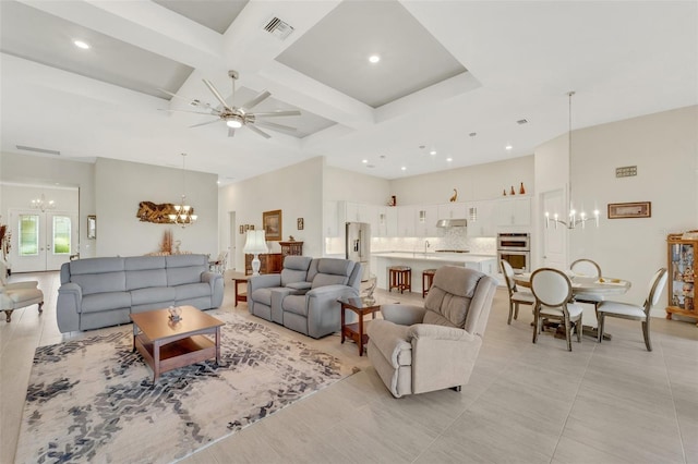 living room featuring beam ceiling, coffered ceiling, light tile patterned floors, and ceiling fan