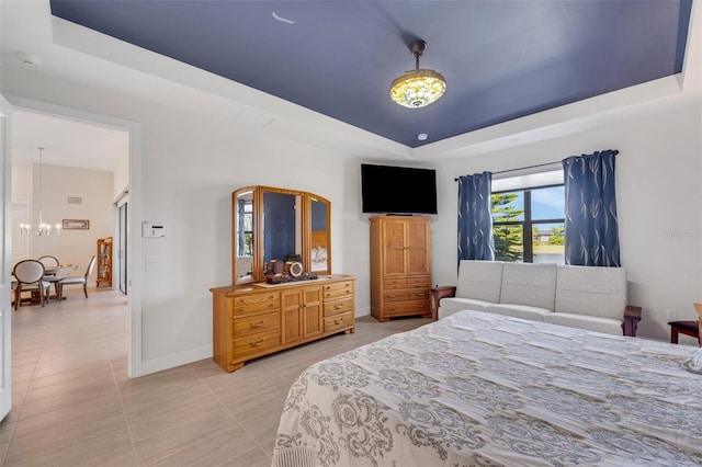 tiled bedroom featuring a raised ceiling and a chandelier