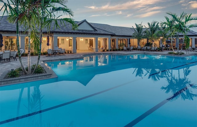 pool at dusk with a patio area