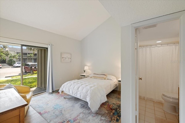 bedroom with light tile patterned floors, access to outside, and lofted ceiling