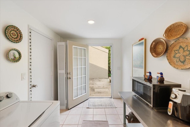 doorway to outside with light tile patterned floors and washer / clothes dryer