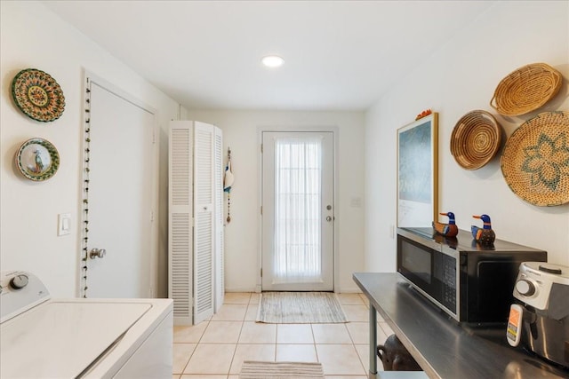 doorway featuring light tile patterned flooring and washer / clothes dryer