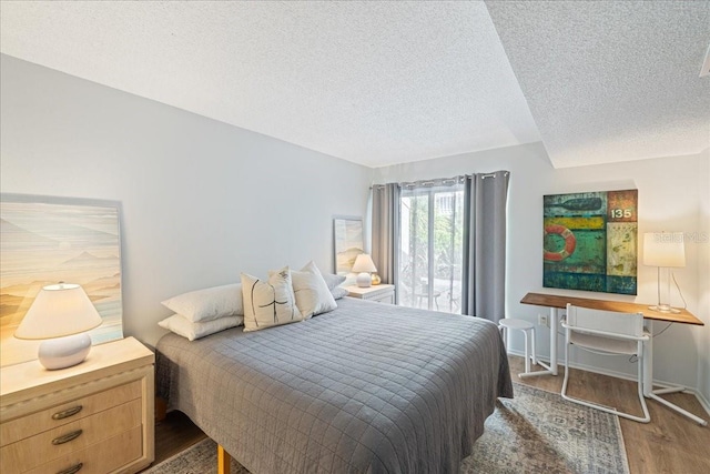 bedroom featuring a textured ceiling and dark hardwood / wood-style floors