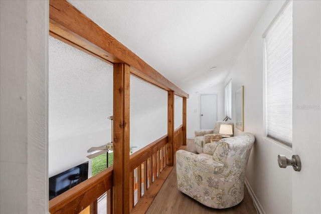 corridor featuring light hardwood / wood-style flooring and vaulted ceiling