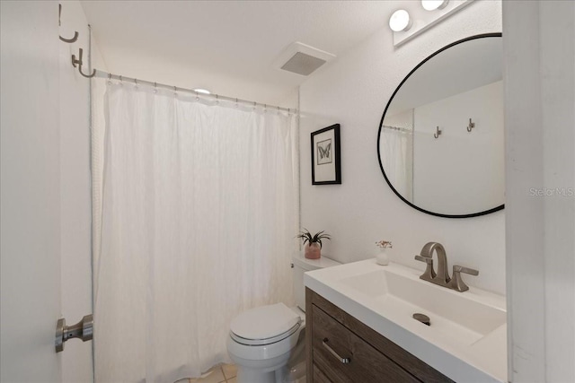 bathroom with vanity, tile patterned floors, toilet, and walk in shower