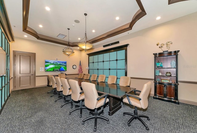 dining room with dark carpet and a raised ceiling