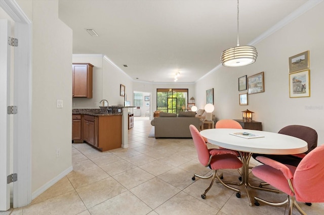 tiled dining room featuring ornamental molding and sink