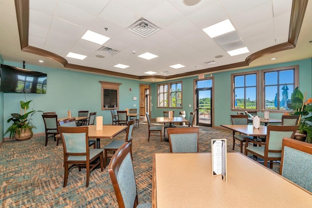 dining space featuring carpet floors, ornamental molding, and a raised ceiling