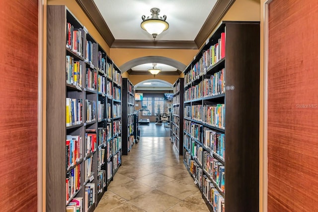 corridor featuring light tile patterned floors and crown molding