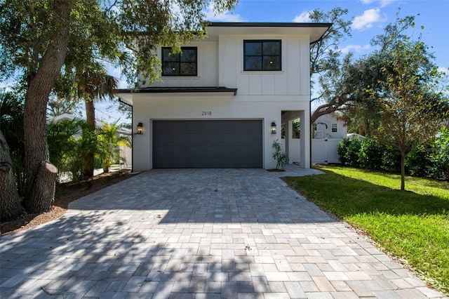 view of front of property featuring a front yard and a garage