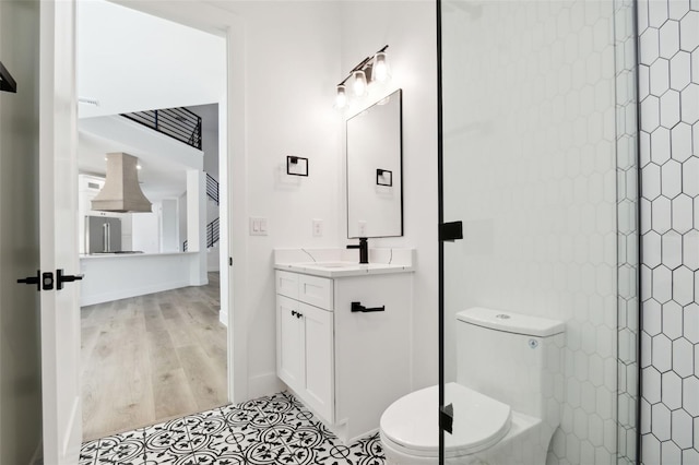 bathroom featuring vanity, toilet, and a shower with shower door