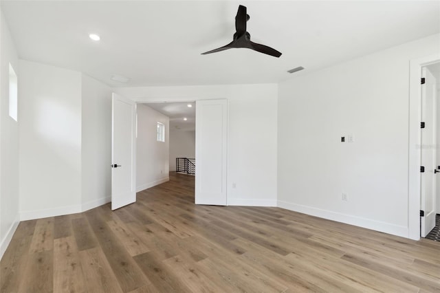 empty room with ceiling fan and light hardwood / wood-style flooring