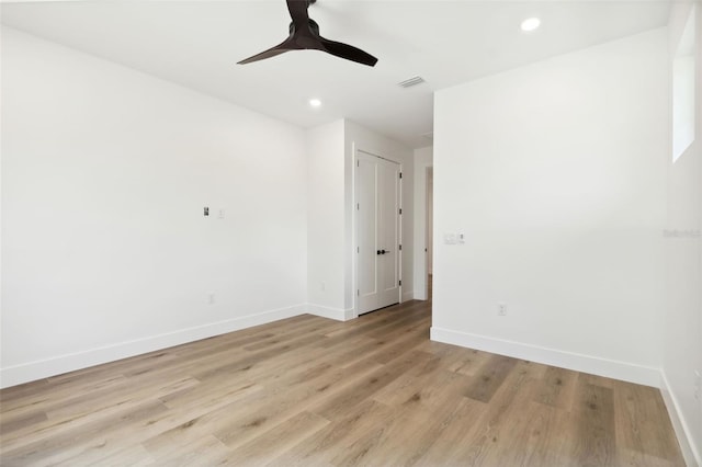 empty room with ceiling fan and light hardwood / wood-style flooring