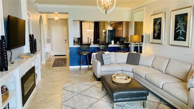 tiled living room featuring crown molding and a notable chandelier