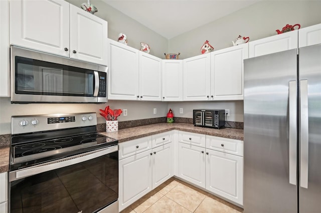 kitchen with white cabinetry, stainless steel appliances, and light tile patterned floors