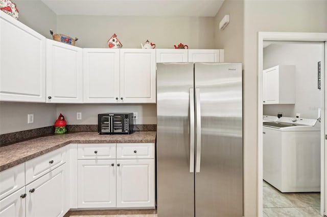 kitchen featuring light tile patterned floors, white cabinets, separate washer and dryer, and stainless steel refrigerator