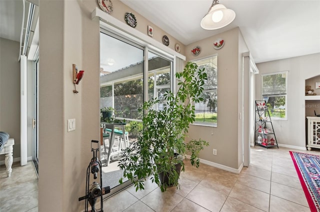 doorway to outside with light tile patterned flooring and a wealth of natural light