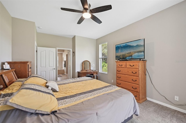 bedroom with connected bathroom, light colored carpet, and ceiling fan