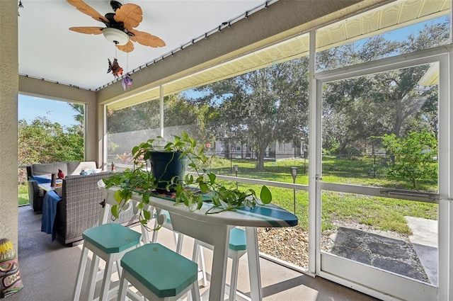 sunroom featuring ceiling fan