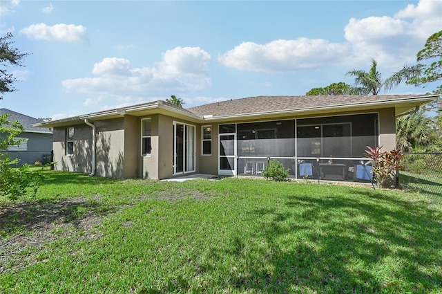 back of property with a yard and a sunroom