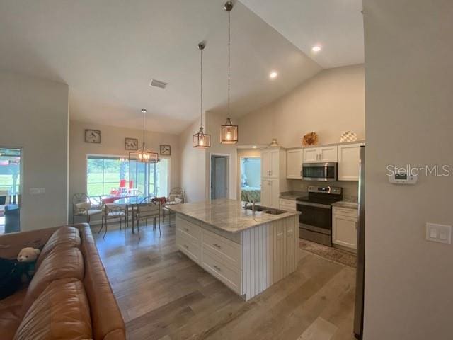 kitchen with a center island, light hardwood / wood-style floors, stainless steel appliances, decorative light fixtures, and white cabinets