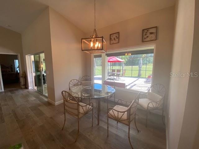 dining area featuring a notable chandelier, lofted ceiling, and dark hardwood / wood-style flooring