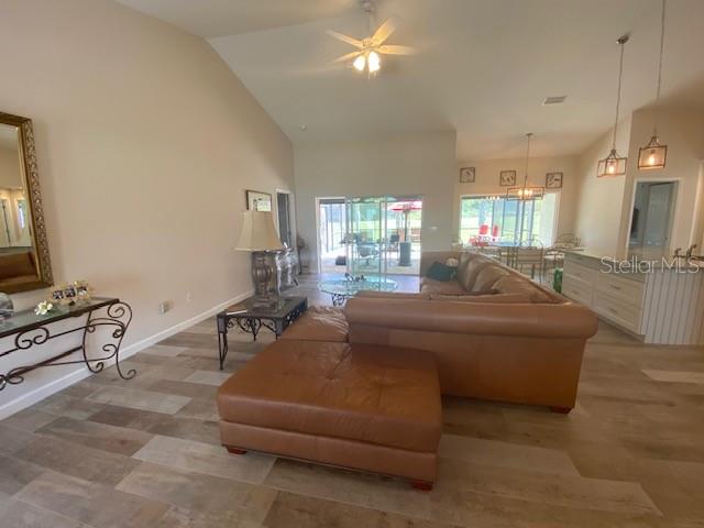 living room with ceiling fan and high vaulted ceiling