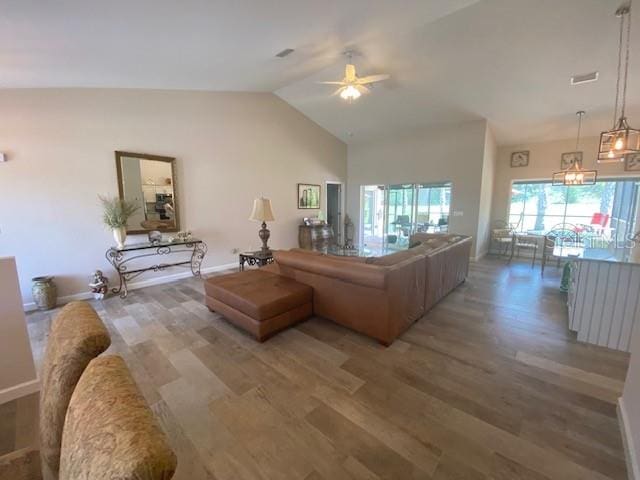 living room featuring hardwood / wood-style flooring, ceiling fan, and vaulted ceiling