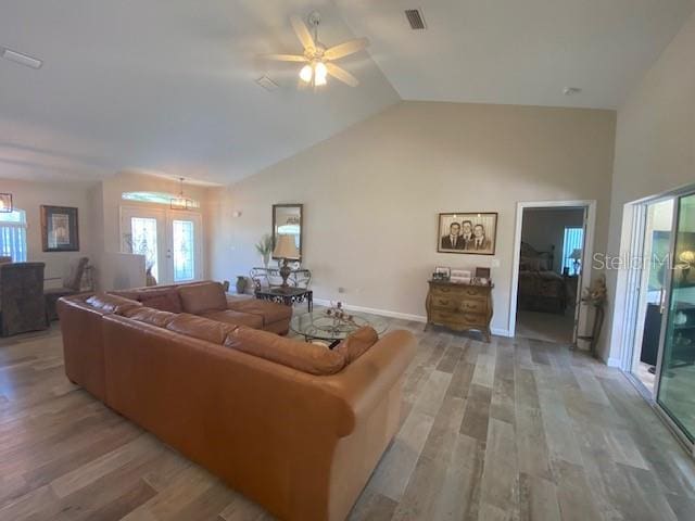 living room featuring french doors, light hardwood / wood-style floors, lofted ceiling, and ceiling fan