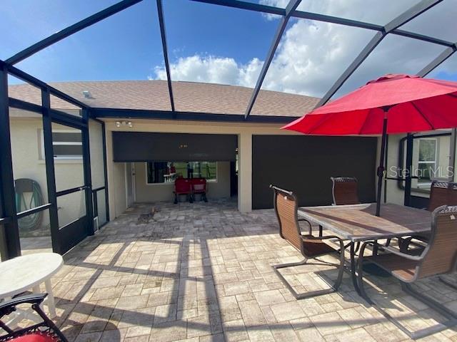 view of patio featuring glass enclosure