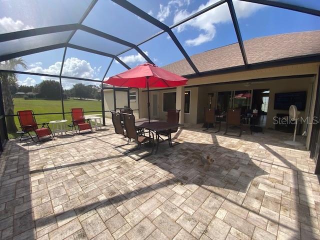 view of patio featuring glass enclosure