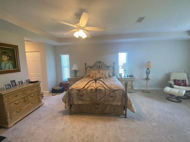 carpeted bedroom featuring a closet, ceiling fan, and multiple windows