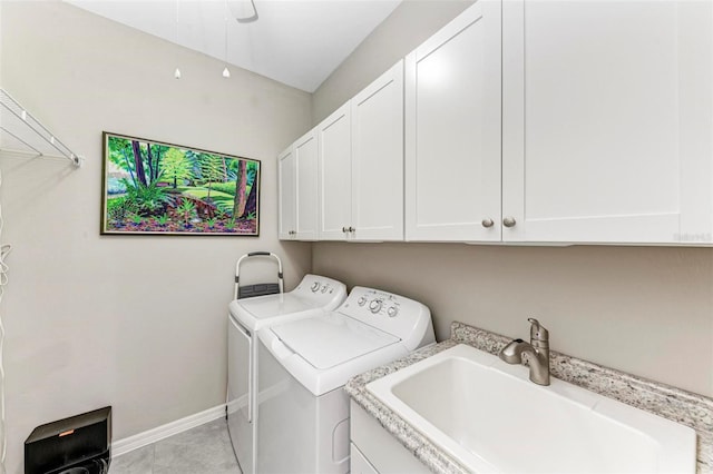 laundry area featuring washer and dryer, light tile patterned flooring, cabinets, and sink