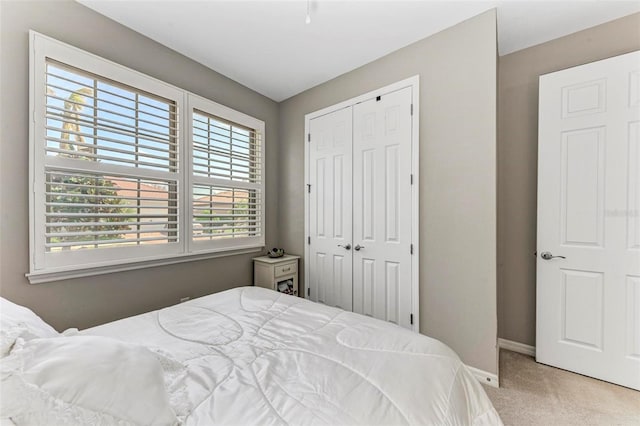 bedroom with light carpet and a closet