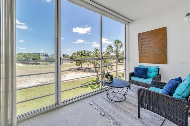 sunroom featuring a water view