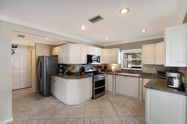 kitchen featuring appliances with stainless steel finishes, light tile patterned flooring, sink, white cabinets, and crown molding