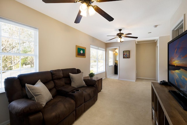 living room featuring a wealth of natural light, light colored carpet, and ceiling fan