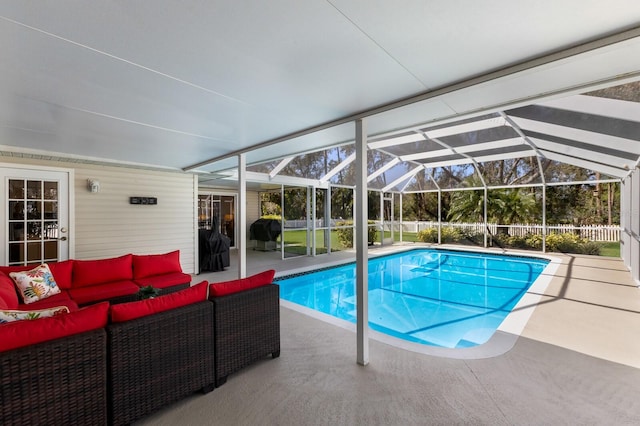 view of pool featuring a patio area, outdoor lounge area, and glass enclosure