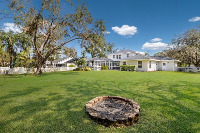 view of yard with an outdoor fire pit and glass enclosure