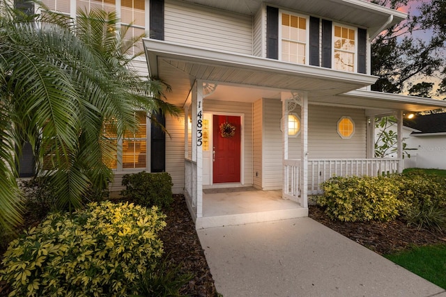 exterior entry at dusk featuring covered porch