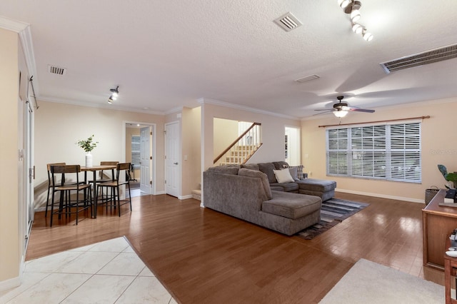 living room with ceiling fan, ornamental molding, and light hardwood / wood-style flooring