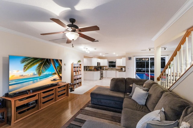 living room with crown molding, light wood-type flooring, and ceiling fan