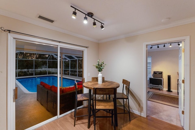 dining room with ornamental molding and hardwood / wood-style floors